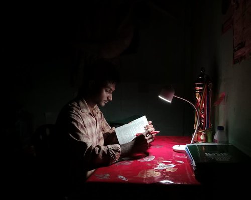 Indonesian evening reading scene with desk lamp