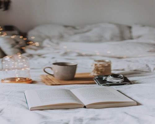 Comfortable reading table with book tea and lamp